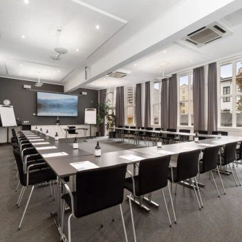 Stort lokale med tavle, stole og bord